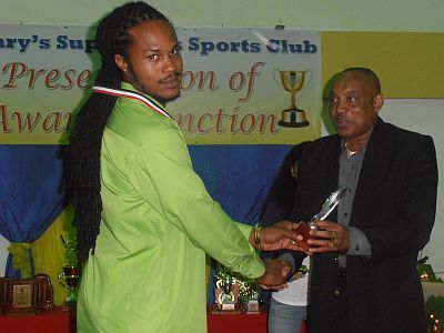2014 FLASHBACK: Devon Boyce, left, collects an award for taking the most wickets (46) from Sam Phillip an executive member of the Trinidad and Tobago Cricket Board (T&TCB).