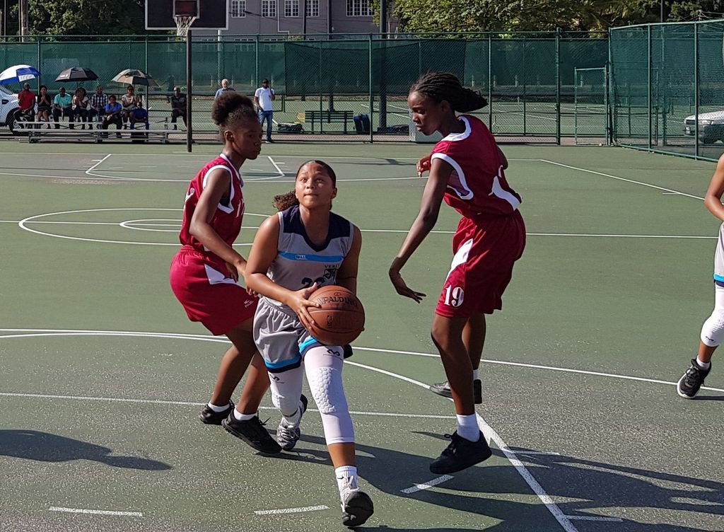 Ty Warwick of Holy Name Convent splits the defence of East Mucurapo Secondary School during the T&T Secondary Schools' Basketball Association North Zone League at the Nelson Mandela Park in St Clair, Port-of-Spain on Thursday. Holy Name won 19-11.
