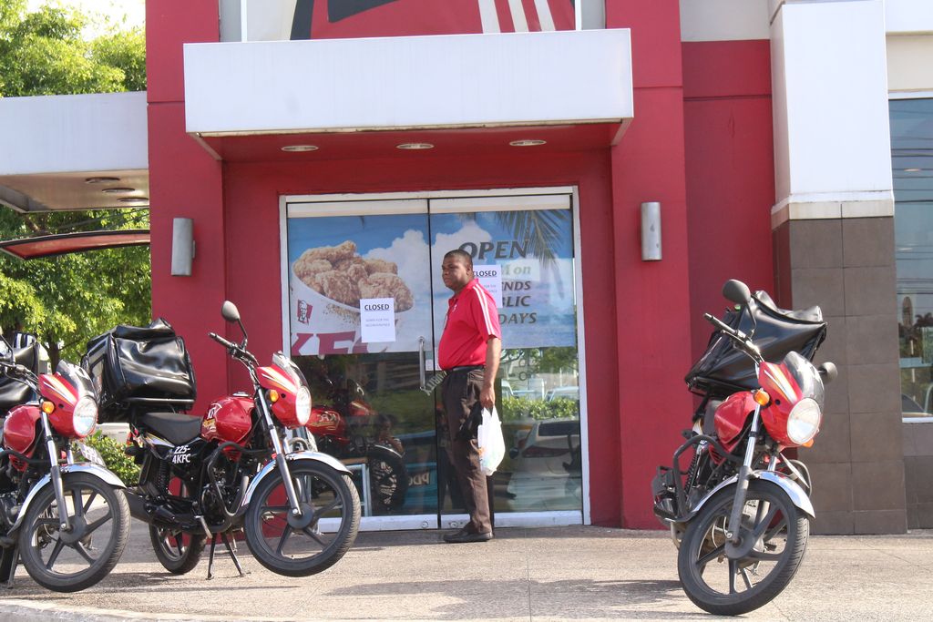 A KFC employee waits to go inside their Westmoorings branch