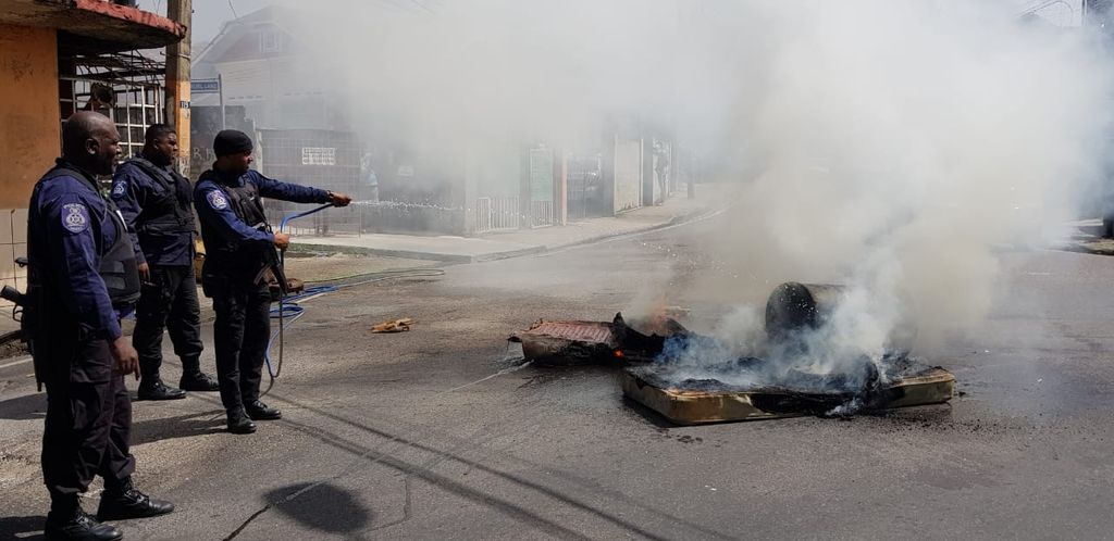 Police attempt to put out a fire during the protest.