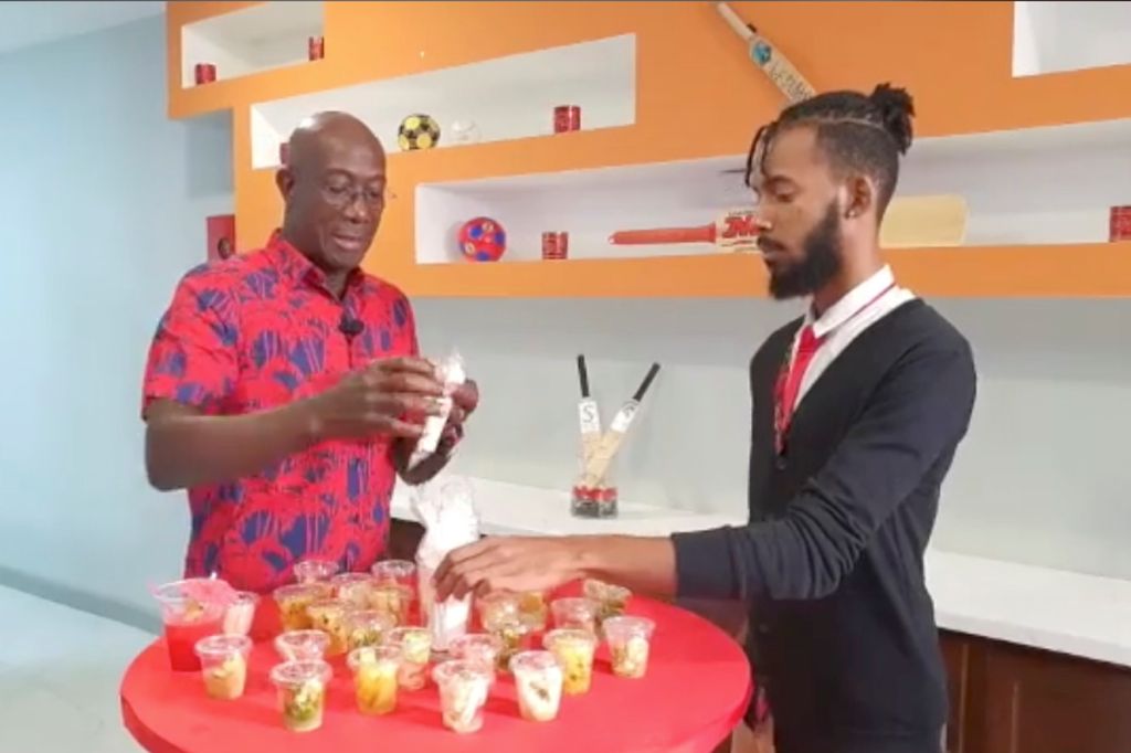 Prime Minister Dr Keith Rowley gets ready to try a sample of a cocktail from bartender Emmanuel Benjamin during his Friday Night Lime virtual event.