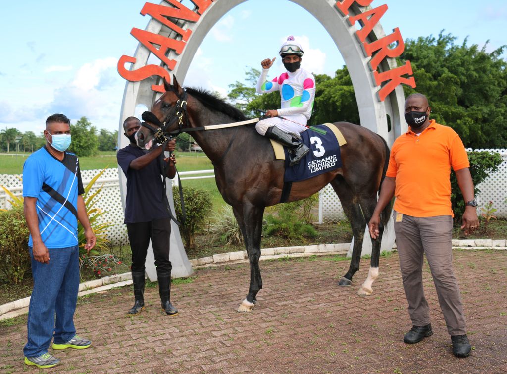 Connections of Juice Man with veteran jockey Ricky Jadoo aboard in winner’s enclosure after the horse wonrace six, the Modified Benchmark Handicap for three-year-old and over horses rated 90 and over, going 1,750 metres on the main track out at Santa Rosa Park, Arima on Saturday.