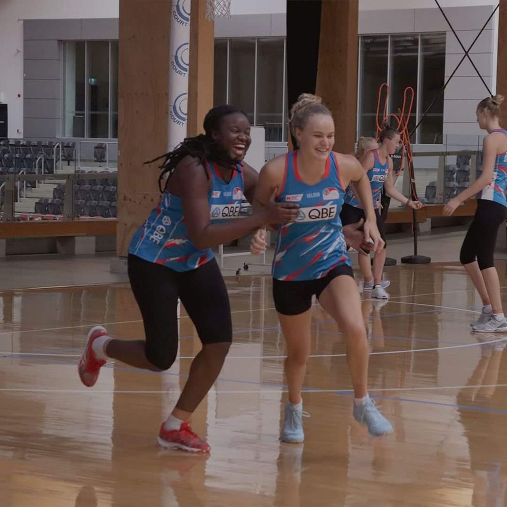 T&T's Samantha Wallace, left, and her teammate have a little fun during a training session of the New South Wales Swifts netball team in Australia on Monday.