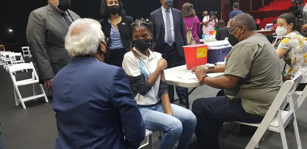 Health Minister Terrence Deyalsingh chats with a lady waiting to receive her COVID-19 vaccine, at the NAPA mass vaccination site, on Friday 23 July 2021. (Image: CARISA LEE)