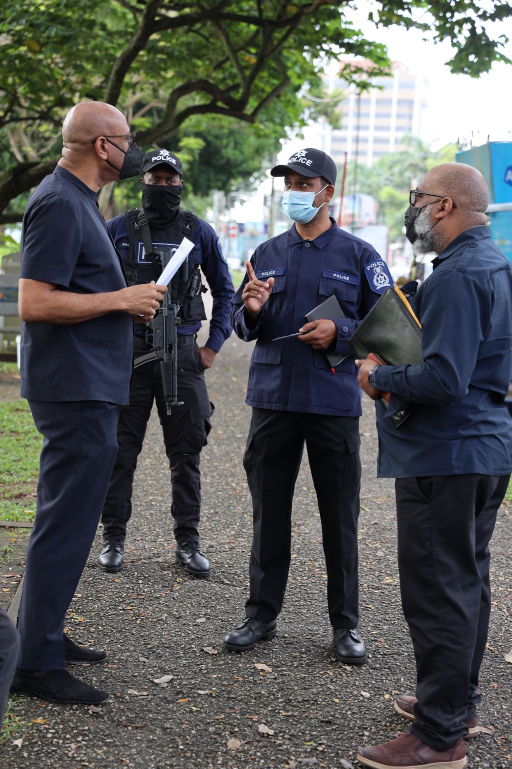 File image: TTPS officers make a point to JTUM President Ancel Roget, left, and OWTU Education officer Ozzie Warwick.