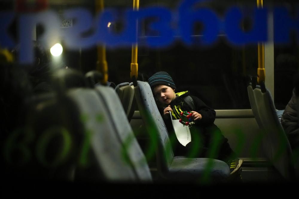 A child who fled from Mariupol with his family waits in a bus upon their arrival at a reception center for displaced people in Zaporizhzhia, Ukraine, late Sunday, May 8, 2022. Thousands of Ukrainians continue to leave Russian-occupied areas. (AP Photo/Francisco Seco)