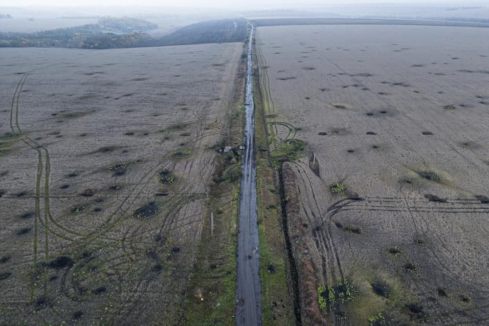 Artillery craters are seen in the field from an arial view in the recently liberated area of Kharkiv region, Ukraine, Friday, Sept. 30, 2022. (AP Photo/Evgeniy Maloletka)