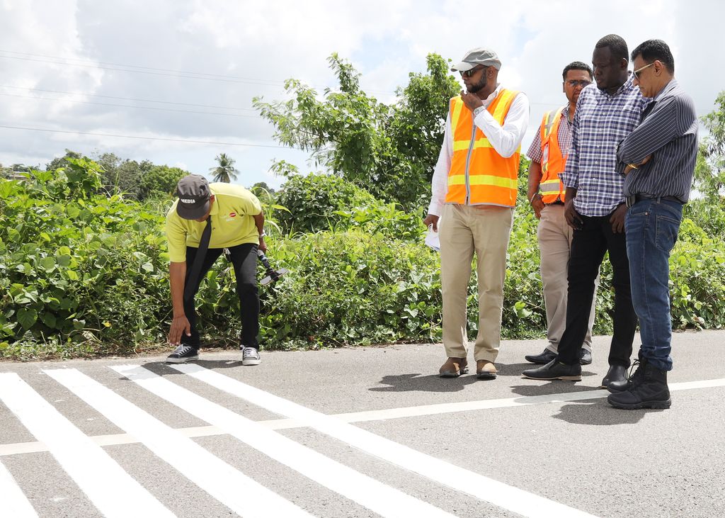 Minister of Works and Transport Rohan Sinanan, right, during his visit to the Solomon Hochoy Highway in Debe on Tuesday to see the operation of the Profile Paint Machine.