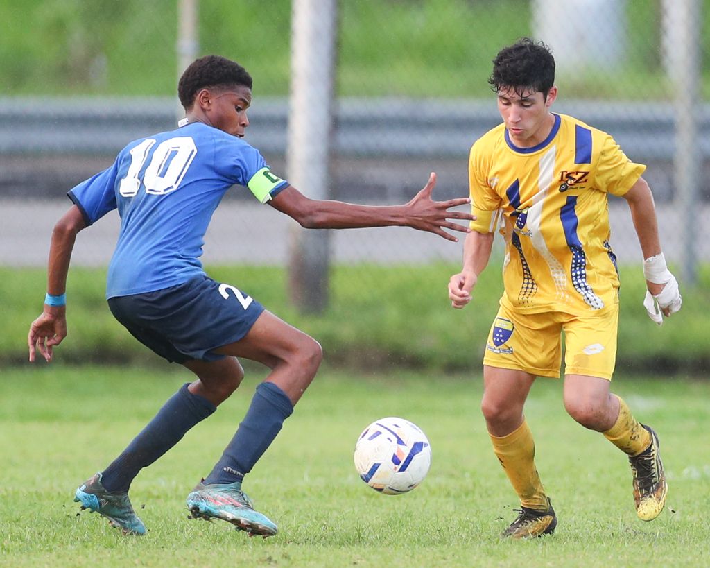 Fatima's Seth Hadeed, right, tries to get by opposing captain of QRC, Phillip Nelson, to keep possession during the Secondary School Football League North Zone Under-14 match at the Hasely Crawford Training Field, Mucurapo on Tuesday. Seth scored the winner in Fatima's 3-2 win. (Photo by Daniel Prentice)