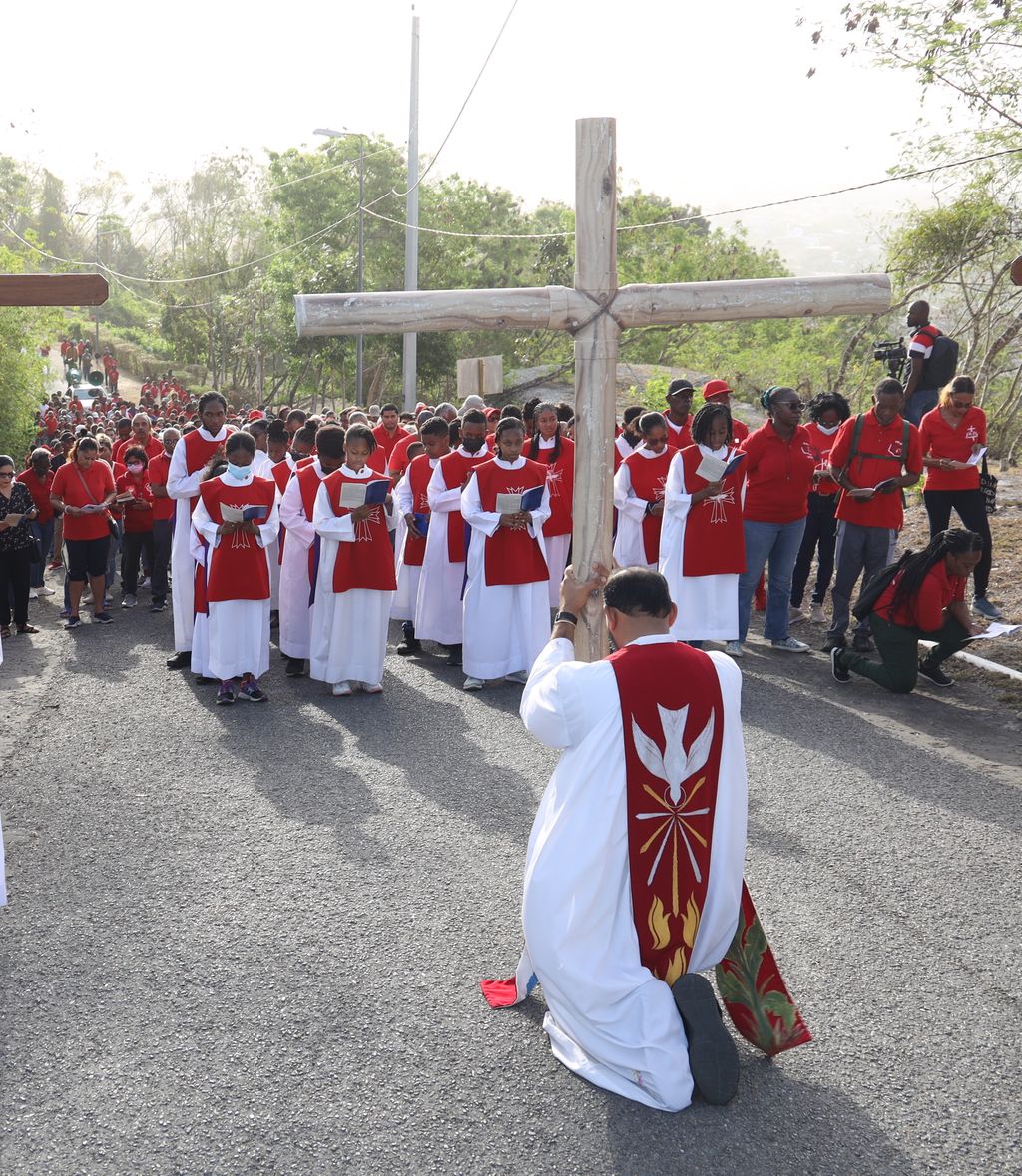 RC priest Father David Khan, centre, carries the cross during the Good Friday Stations of the Cross procession, on San Fernando Hill, yesterday. 