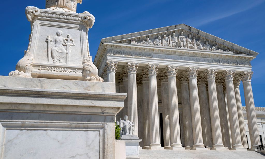 FILE - The U.S. Supreme Court is seen, with a carving of Justice in the foreground, April 19, 2023, in Washington. A Black Ohio woman who miscarried in her bathroom has been charged with abuse of a corpse and awaits grand jury action. Her case has sparked a national firestorm over the plight of pregnant women, especially women of color, following the U.S. Supreme Courtâ€™s decision to overturn Roe v. Wade. (AP Photo/Jacquelyn Martin, File)