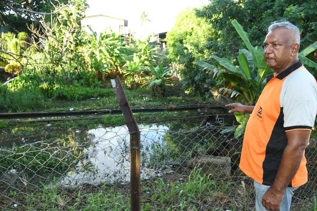 Disgruntled Balmain, Couva, resident Gowkaran Ramlagan points to a pool of water caused by a clogged drain, which is a breeding ground for  mosquitoes.