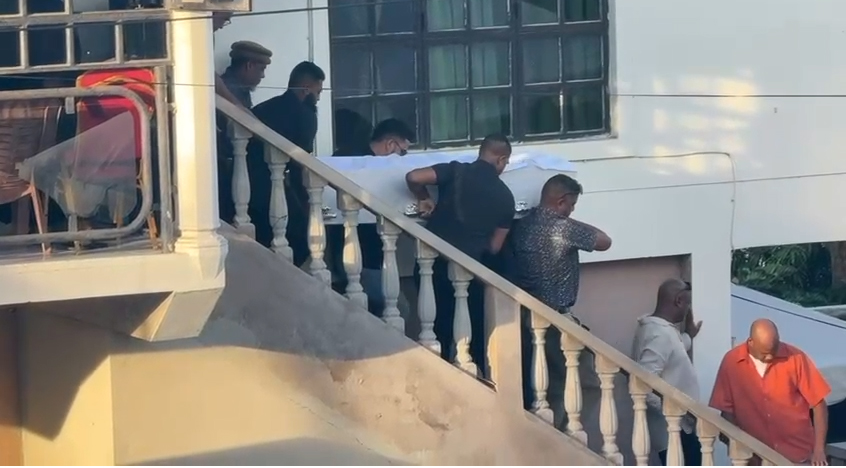 Pallbearers carry the casket of murdered driver Saleem Abdool down the staircase of his Church Street, La Romain home after his funeral service yesterday.