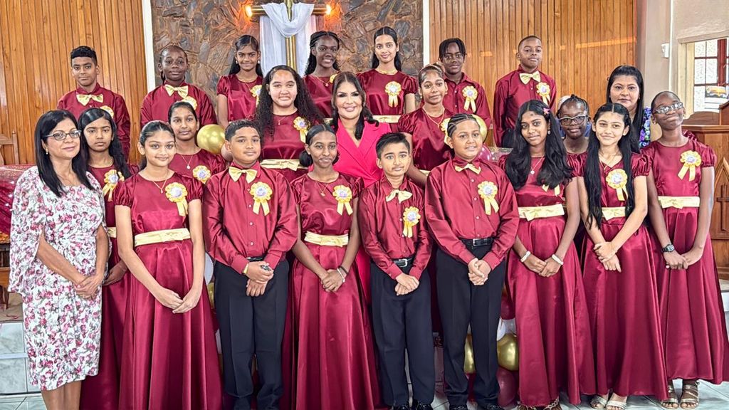 Former journalist Hema Ramkissoon, centre, in the second row, poses with the 2025 graduating class of Harmony Hall Presbyterian School at the Wilson Memorial Presbyterian Church in Marabella yesterday.