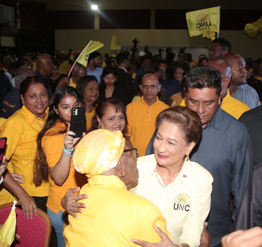 Prime Minister Kamla Persad-Bissessar greets a supporter on her arrival at the party’s Monday Night Report at Clarke Road, Penal, last night.