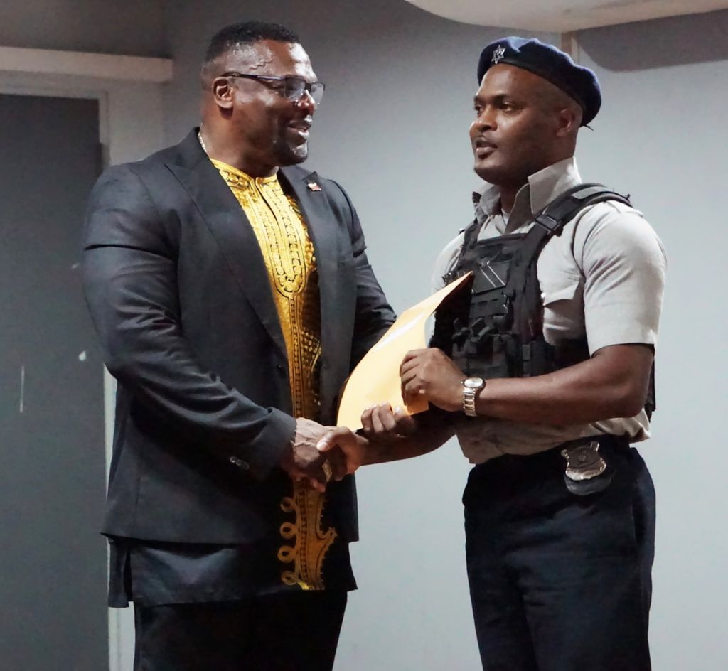 Minister of Homeland Security Roger Alexander presents PC Christian Perez with his award for foiling a robbery in Port-of-Spain last month during a commendation and awards ceremony at the Police Administration Building, Port-of-Spain, on Thursday.